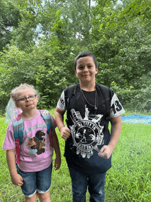 a boy wearing a shirt that says the city of new york stands next to a girl