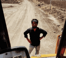 a man with a crown on his head stands on a dirt road