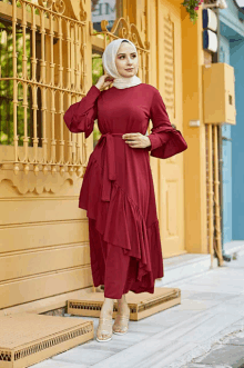 a woman wearing a red dress and a white hijab