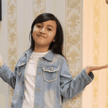 a young girl in a denim jacket and white shirt