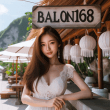 a woman in a white dress stands in front of a sign that reads balon168