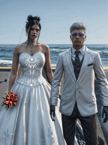 a bride and groom pose for a picture on the beach