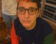 a man wearing glasses and a lacoste shirt