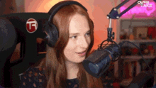 a woman wearing headphones is talking into a microphone in a room .