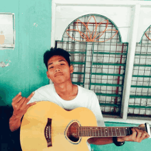 a young man holds a guitar and giving the middle finger