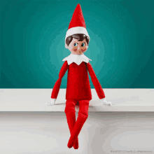 an elf on the shelf is sitting on a shelf with a blue background