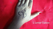 a woman 's hand with a tattoo of the letter b on it