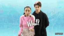 a boy and a girl are standing next to each other and the girl is wearing a pink sweater that says what on it