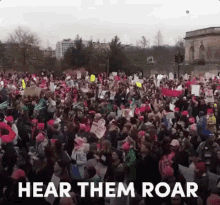 a large crowd of people are gathered in front of a building with the words hear them roar above them