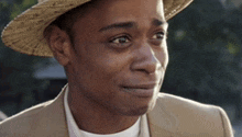 a close up of a man wearing a hat and a tan suit