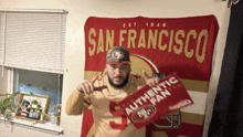 a man holding a sign that says authentic fan in front of a san francisco banner