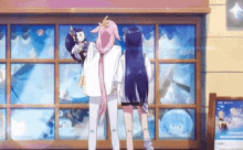 two anime girls are standing in front of a window looking at a doll .