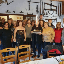 a group of people posing for a picture with a cake that says 80