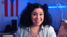 a woman with curly hair is smiling in front of a flag