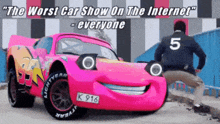 a man standing next to a pink lightning mcqueen car with the number 5 on the back