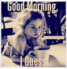 a little girl is sitting at a table with a cup of coffee and a good morning message .