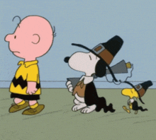 a cartoon of charlie brown and snoopy dressed in pilgrim costumes