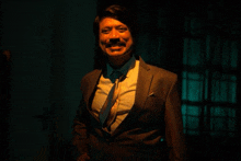 a man in a suit and tie is standing in a dark room