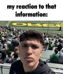 a young man is sitting in the stands at a football game with the words my reaction to that information written above him