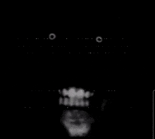 a black and white photo of a person 's face with a beard and teeth in the dark .