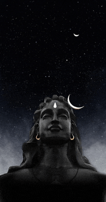 a statue of a man with a crescent moon in the background