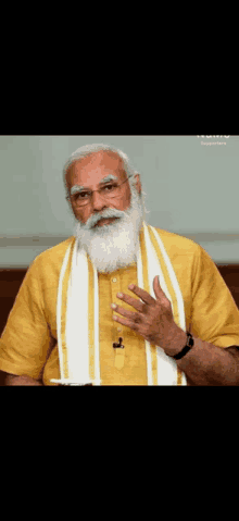 a man with a beard and glasses is wearing a yellow shirt and a white scarf