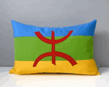 a colorful pillow with a red cross on it