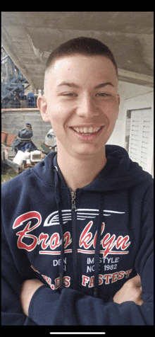 a young man wearing a blue hoodie that says brooklyn on it