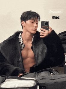 a man in a fur coat takes a picture of himself in a mirror