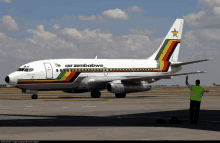 an air zimbabwe plane is parked on the tarmac at an airport