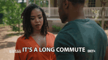 a man and a woman are standing in front of a house with the words it 's a long commute below them