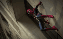 a man in a spiderman costume is climbing a wall