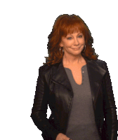 a woman with red hair is wearing a black jacket