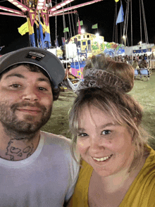 a man and woman are posing for a photo at a carnival