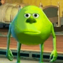 a green monster from monsters inc is standing in front of a bed and looking at the camera .