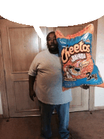 a man holds up a bag of cheetos jumbo