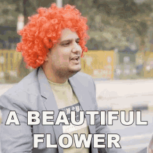 a man wearing a red wig and a suit says a beautiful flower