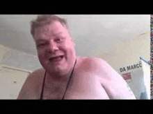 a shirtless man is making a funny face while standing in a room .