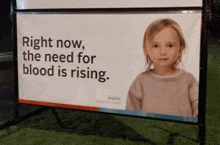 a billboard with a little girl and the words right now the need for blood is rising