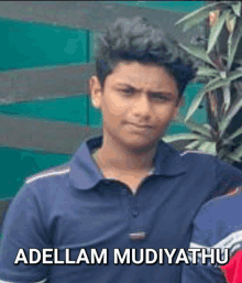 a young man in a blue shirt with the name adellam mudiyathu written on the bottom