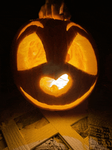 a pumpkin with a face carved into it sits on a piece of plywood that says react