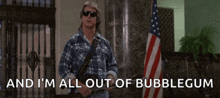 a man holding a gun in front of an american flag with the words " and i 'm all out of bubblegum "