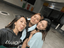 three girls pose in front of a helix oil change