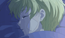 a girl with green hair is laying in bed with a patch on her face .