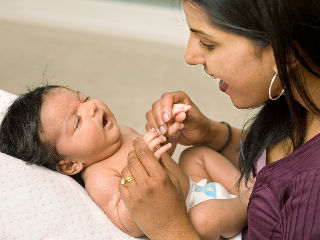 Smiling mother holding her baby bump