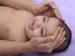 Baby being massaged and smiling