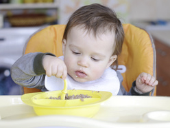 niño pequeño comiendo lentejas