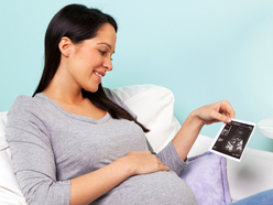 Pregnant woman looking at her scan photo