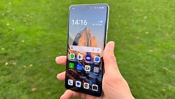 Oppo Find X8 in der Hand gehalten, im Hintergrund eine grüne Wiese.