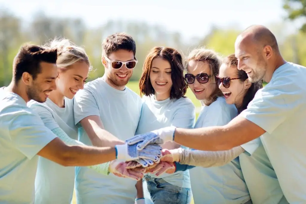 Image of 7 people in gardening gloves putting their hands in together